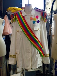 a white jacket with a rainbow sash on a mannequin