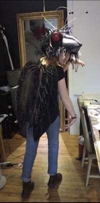 a woman in a costume standing in front of a desk