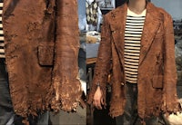 a mannequin wearing a brown leather jacket