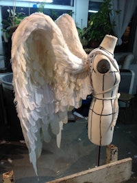 a mannequin with white wings on a stand